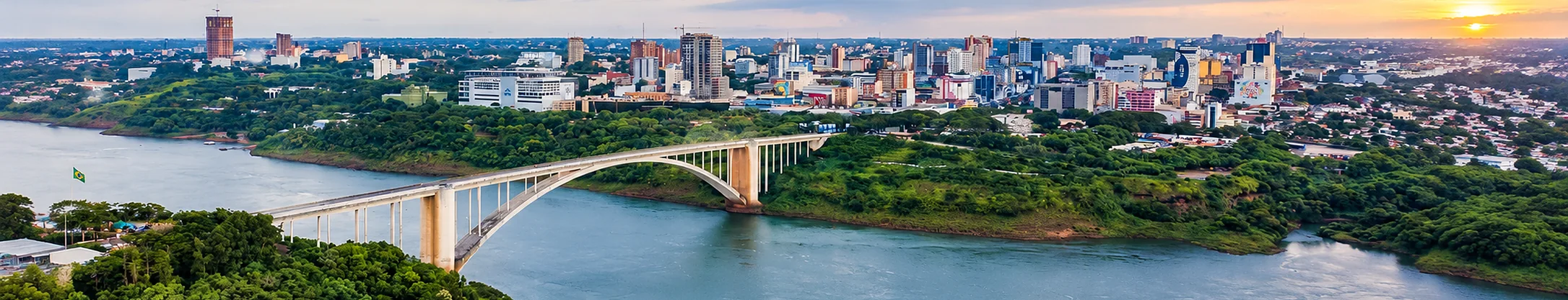 Vista aérea de Ciudad del Este e da Ponte da Amizade sobre o rio Paraná, no fim da tarde.